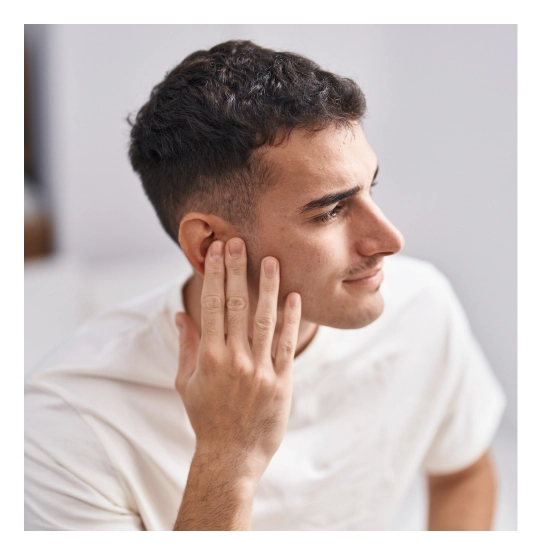 Young man with fade haircut touching face while smiling, wearing white t-shirt - in Clifton, NJ