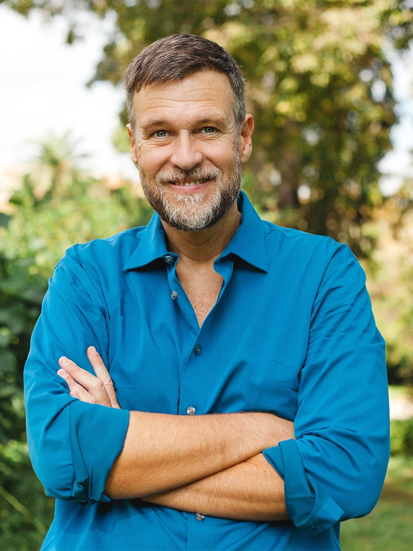 Professional headshot of smiling middle-aged man with beard wearing blue shirt outdoors with green background - Erectile dysfunction in Clifton, NJ