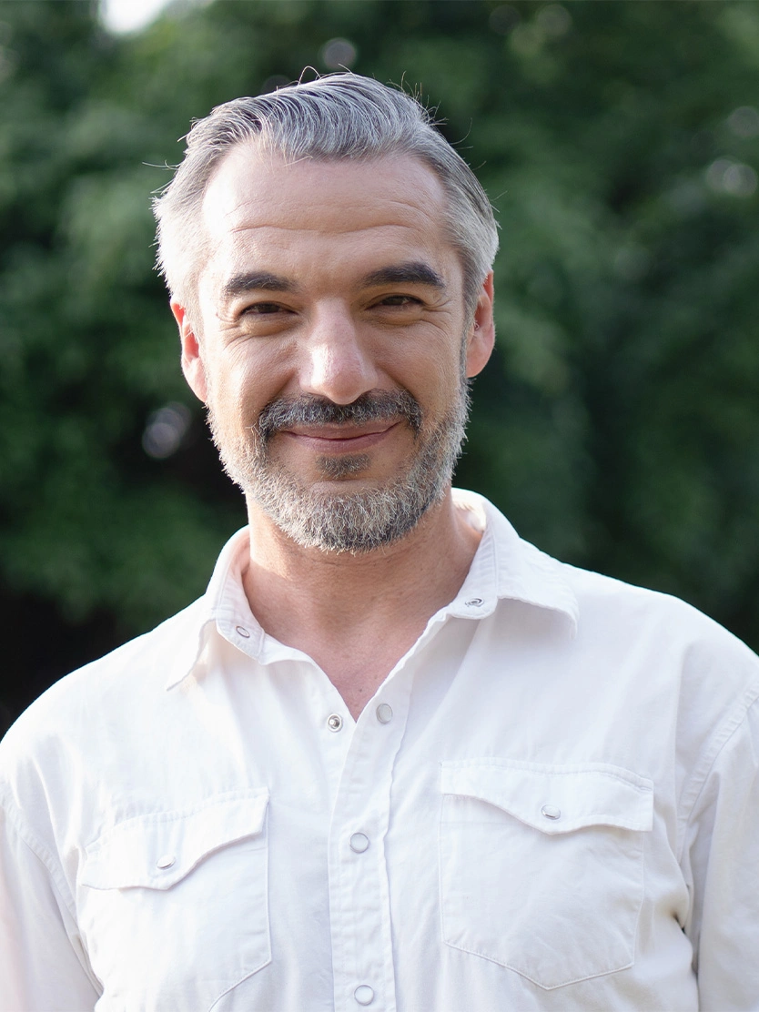 Professional headshot of smiling middle-aged man with gray beard wearing white shirt outdoors - Hydrocele repair in Clifton, NJ