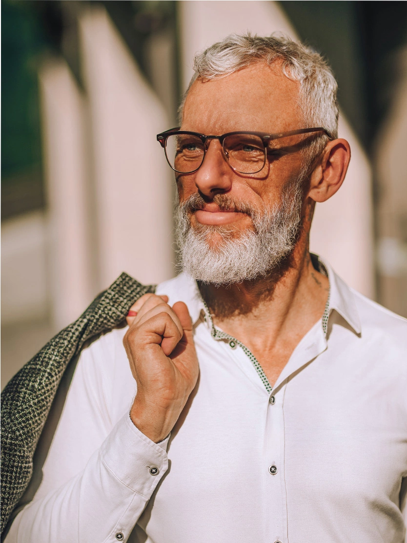 Distinguished mature businessman with gray beard and glasses holding jacket over shoulder - ureteroscopy with laser lithotripsy in Clifton, NJ